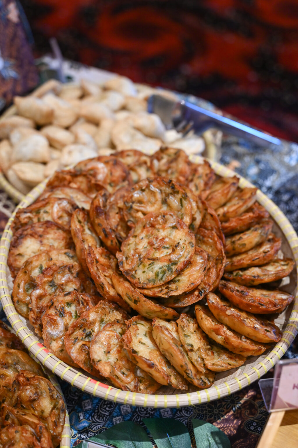 Rattan tray of cucur udang prawn fritters with curry puffs behind, iDoCatering Hari Raya spread at Mercu UEM