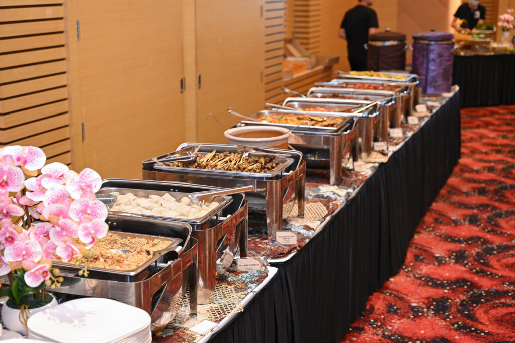 Buffet line with lemang santan, chicken satay skewers and chafing dishes at a Hari Raya corporate event, Mercu UEM