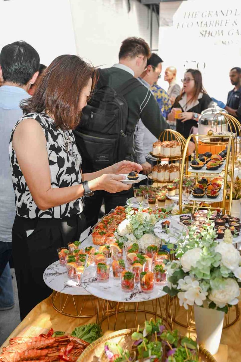 Guests picking canapes from iDoCatering dessert and appetiser table at the Eco Marble grand opening 2025