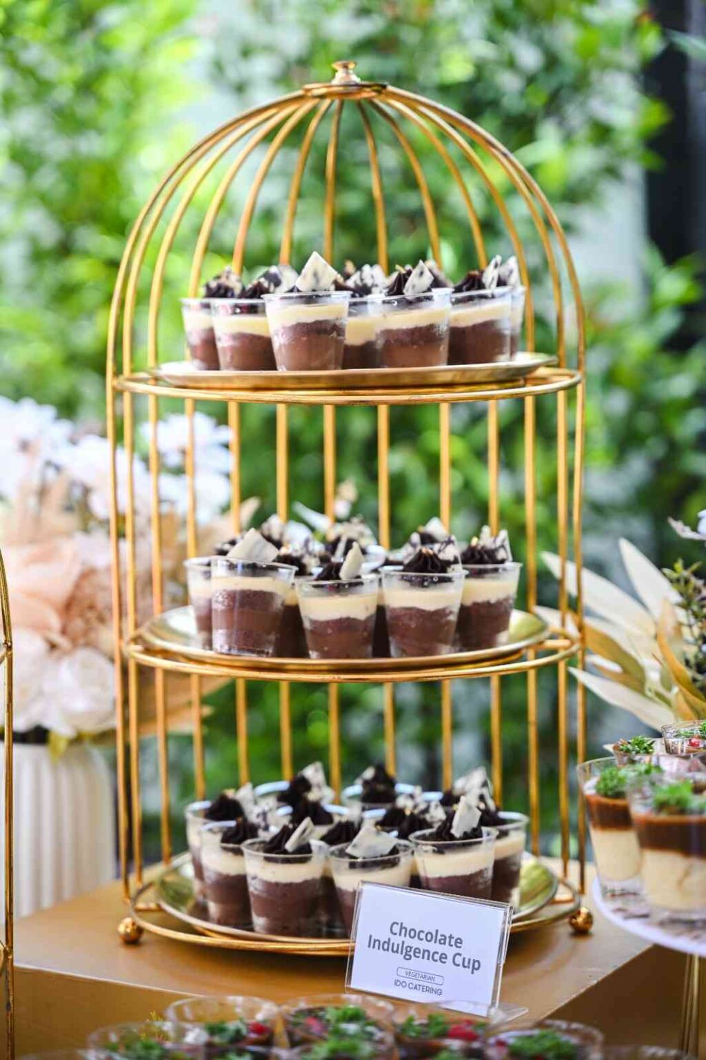 Gold birdcage stand of iDoCatering Chocolate Indulgence Cup desserts at the Eco Marble grand opening 2025
