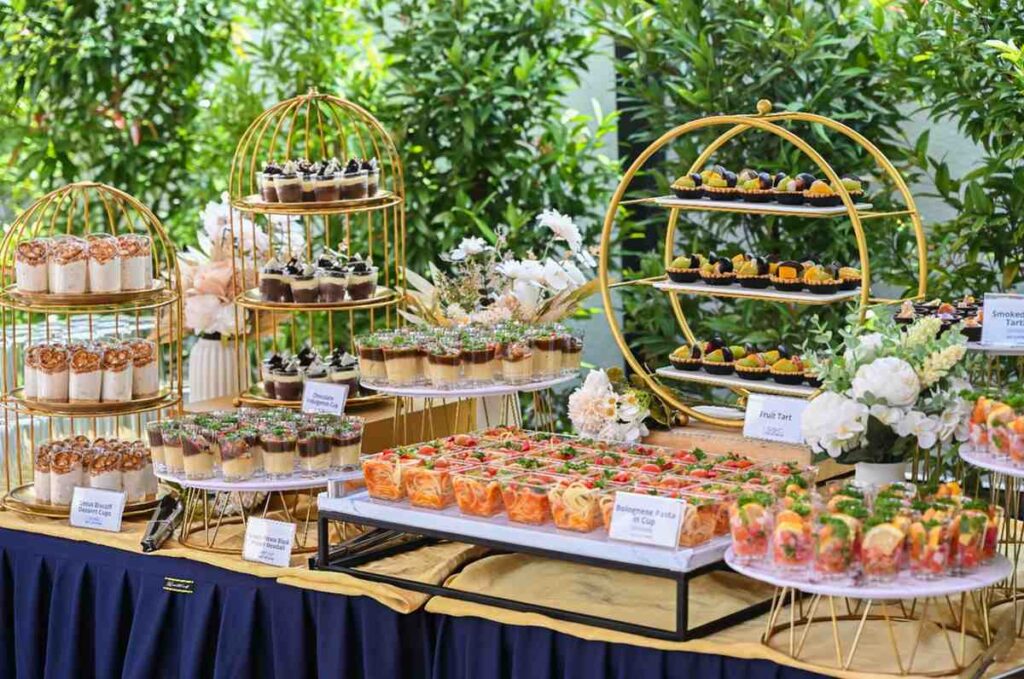 iDoCatering refreshment table with fruit tarts, dessert cups and pasta cups on gold stands, corporate launch