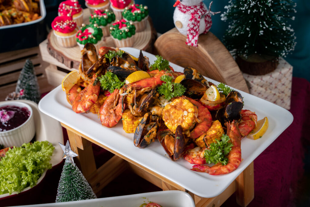 Prawns, mussels and corn in a buttery sauce on a white platter at an iDoCatering Christmas buffet