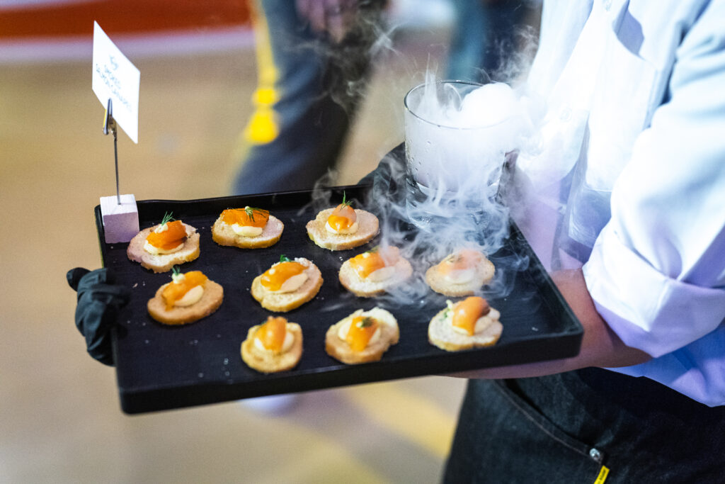 Server carrying a tray of smoked salmon canapes with dry-ice smoke at the Mini Cooper launch event