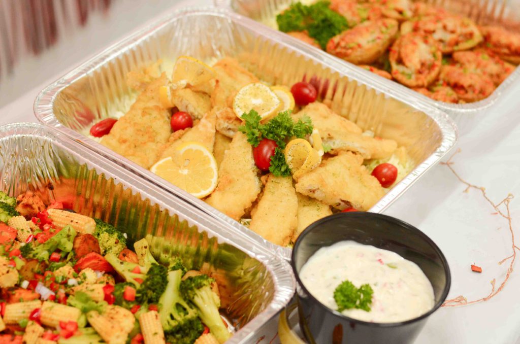 Buffet trays of battered fried fish with lemon, roasted vegetables and tartar sauce, birthday party catering 2022