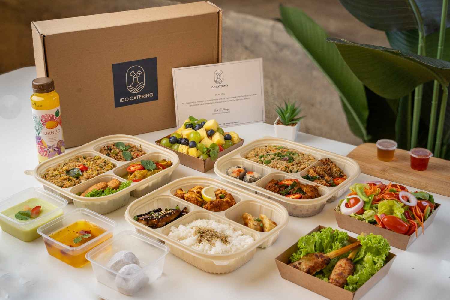 iDoCatering seminar bento spread — three open bento sets with fried rice, curry chicken, salad, fruit and mango juice