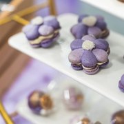 Purple flower themed macarons on a dessert table — iDoCatering