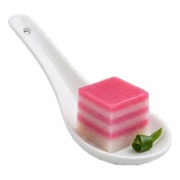 Pink and white layered nyonya kuih served on a ceramic spoon — iDoCatering canapé
