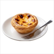 Portuguese egg tart with caramelised custard top on a white plate with a fork — iDoCatering buffet