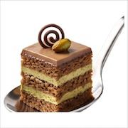 Layered mocha and pistachio cake square with a chocolate curl and pistachio, on a spoon — iDoCatering dessert