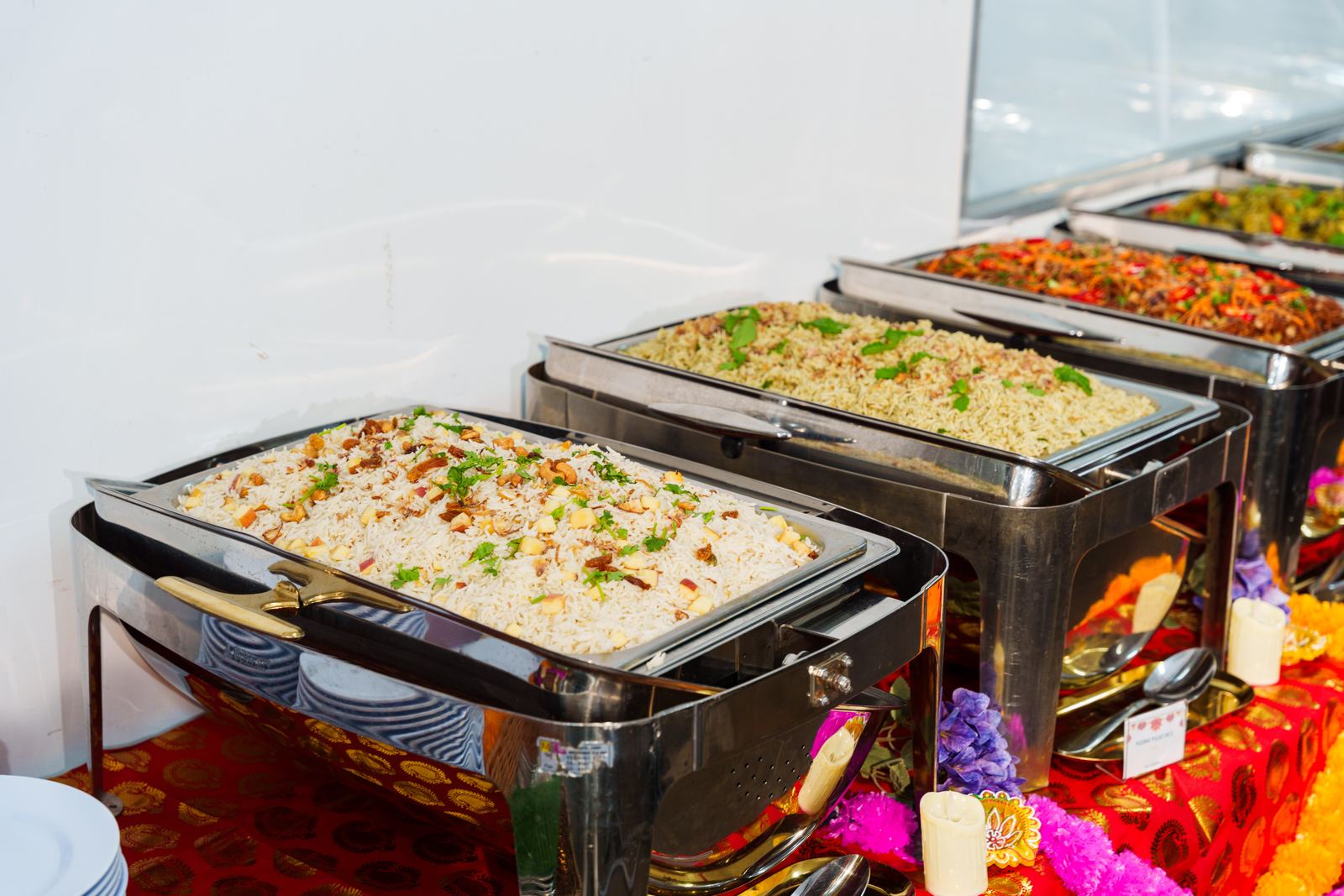 Cashew rice and herbed rice in chafing dishes along an iDoCatering Deepavali buffet line