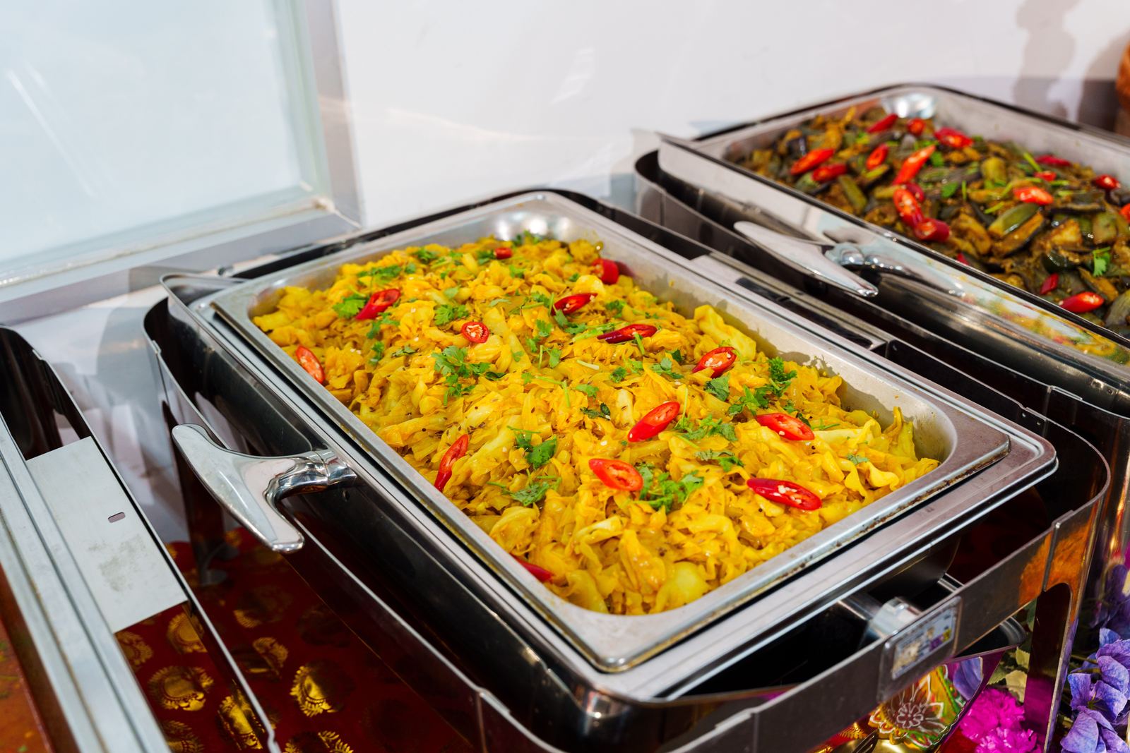 Cabbage masala with turmeric, red chilli and coriander in a chafing dish at a Deepavali buffet