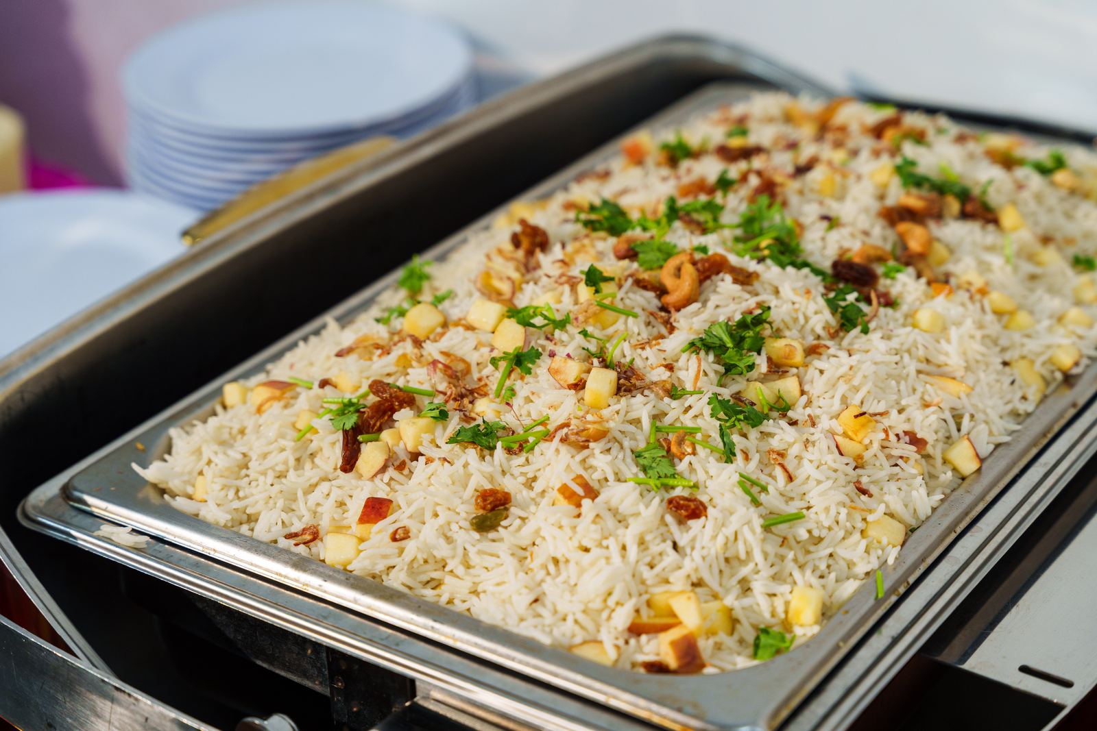 Kashmiri rice with cashews, raisins and diced apple in a chafing dish at a Deepavali buffet