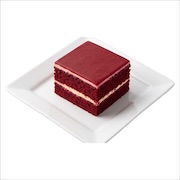 Red velvet cake slice, two red sponge layers with cream cheese filling under a red glaze — iDoCatering