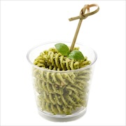 Pesto fusilli in a clear cup topped with a basil leaf, with a bamboo skewer — iDoCatering canapé