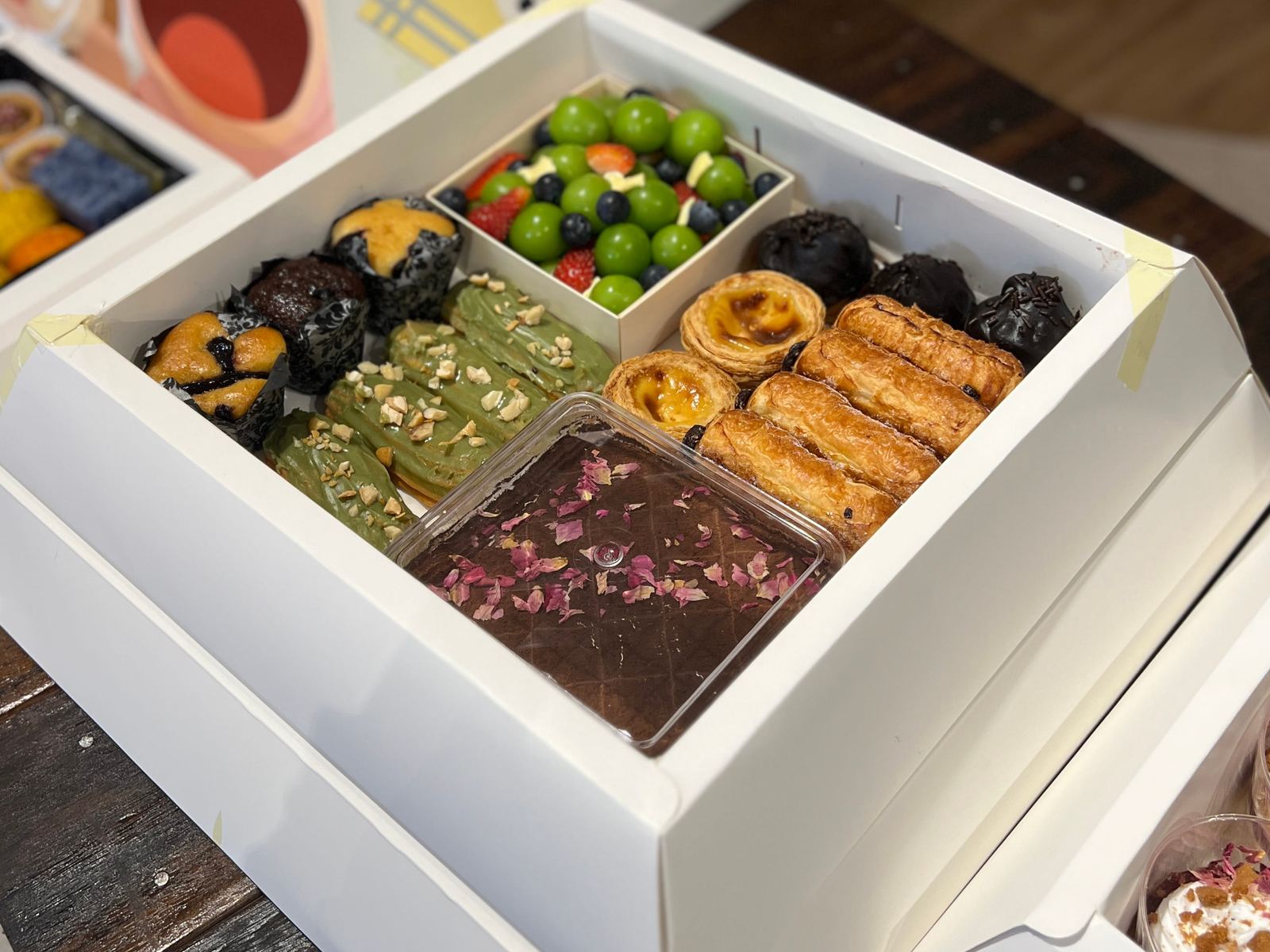 Portuguese egg tarts, eclairs, chocolate danish and a mini cheese and fruit platter in the iDoCatering Pyramid Dessert Box