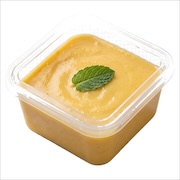 Smooth golden pudding topped with a mint leaf in a clear iDoCatering takeaway container