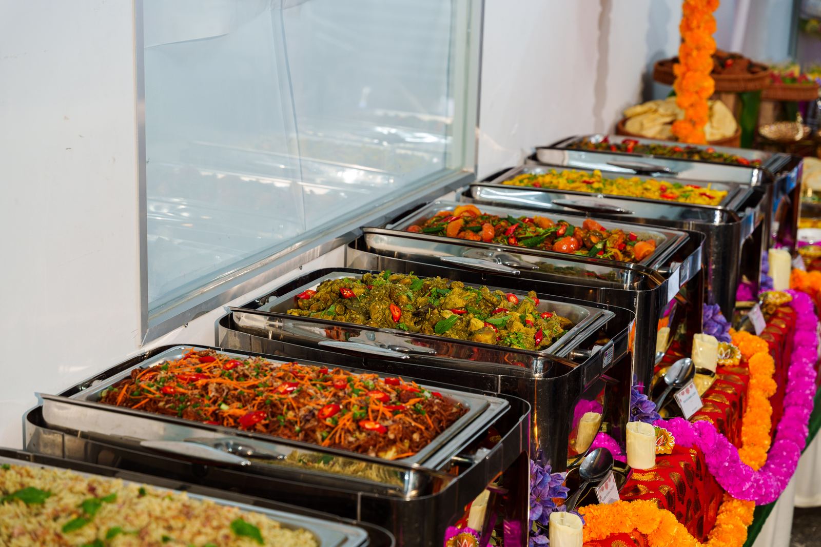 iDoCatering Deepavali buffet line of mee goreng and curries in chafing dishes dressed with marigold garlands