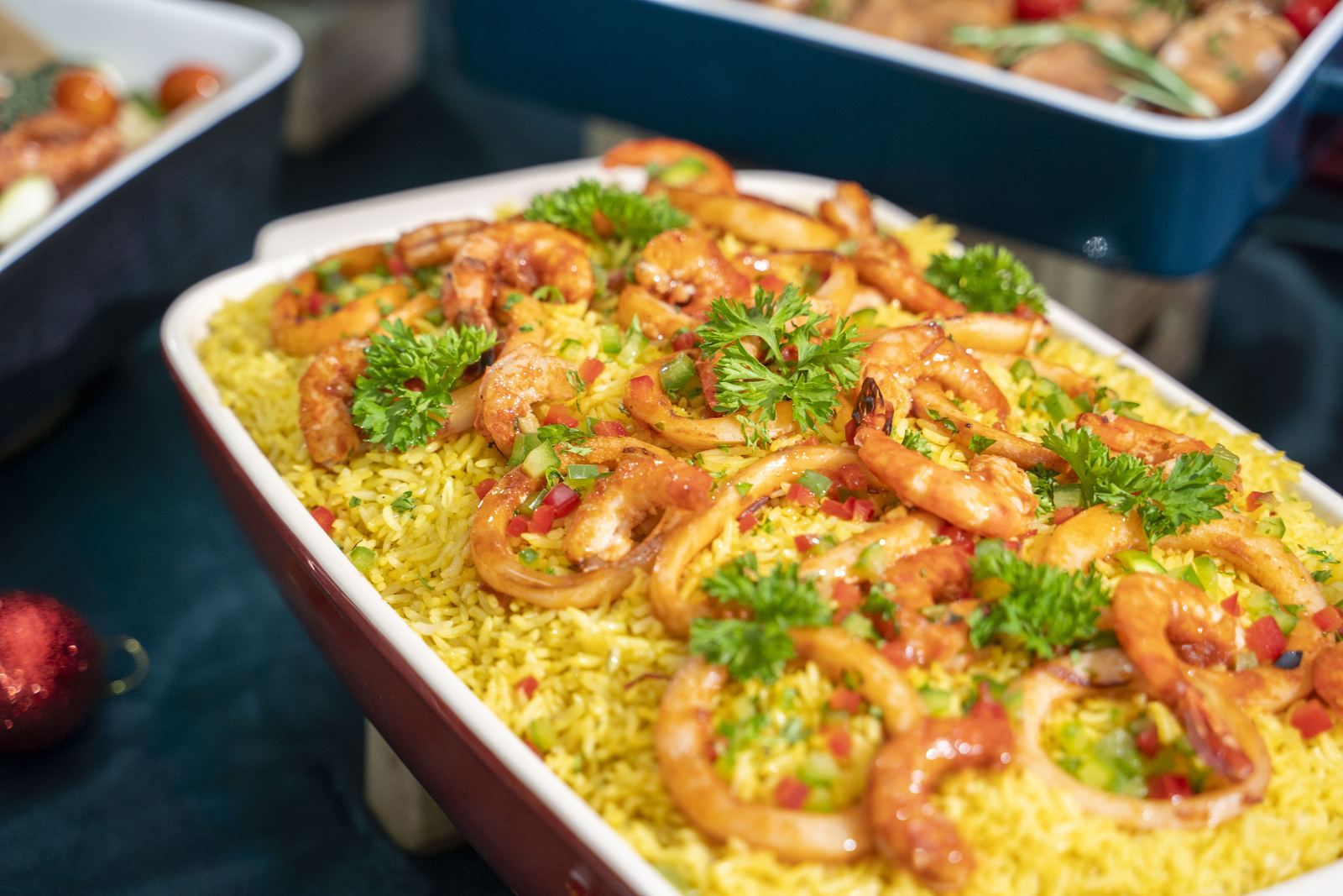 Saffron rice with prawns and squid rings, finished with parsley and diced peppers — iDoCatering