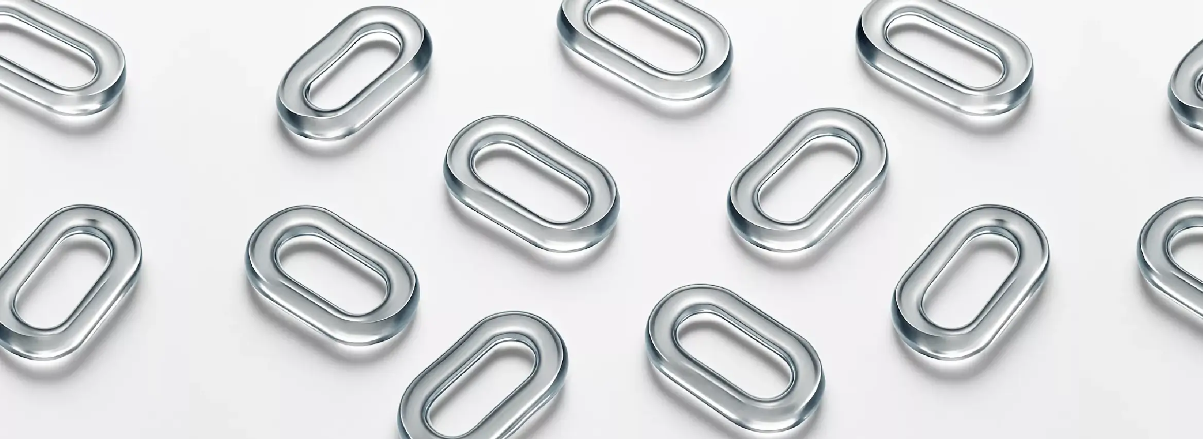  transparent oval-shaped glass rings arranged on a white surface.