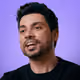 Portrait of Elvis Lion, CEO of Hubmilhas, on a purple background.