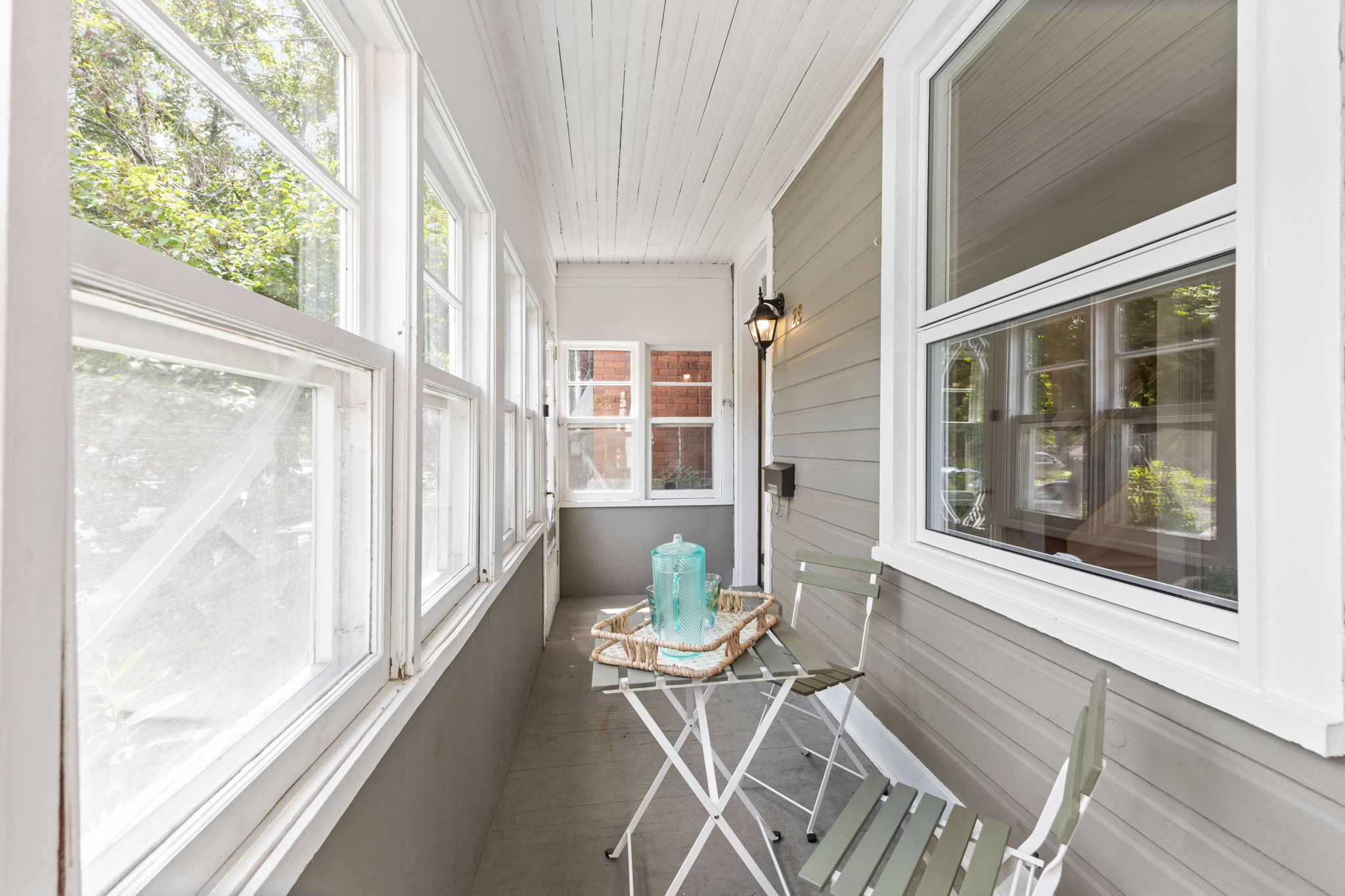 A small table and two chairs on an enclosed porch in Ottawa