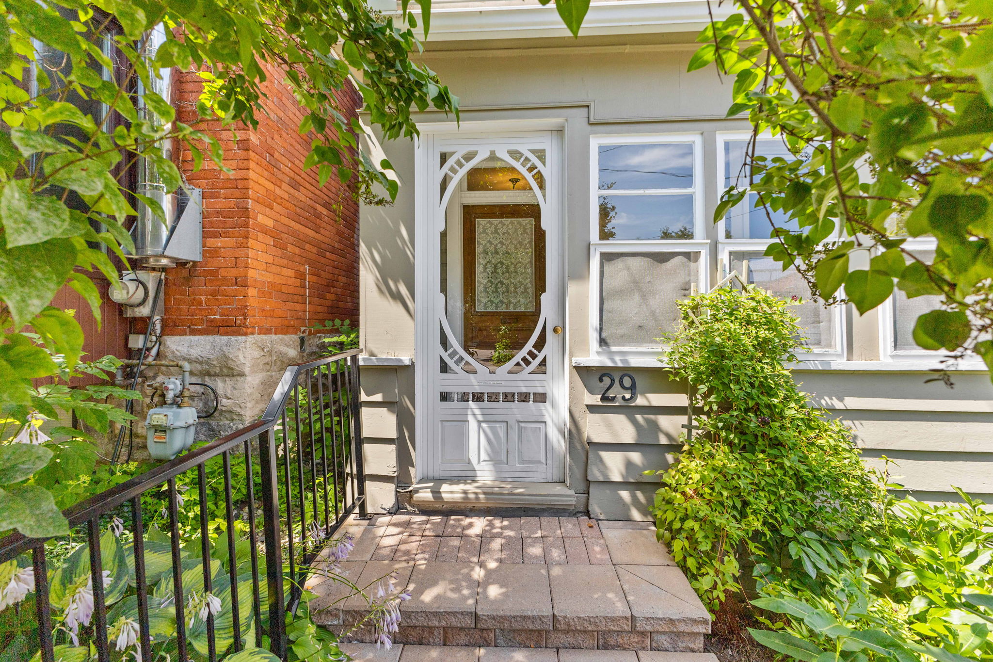 Front door of a character home in Ottawa, framed by brick and greenery