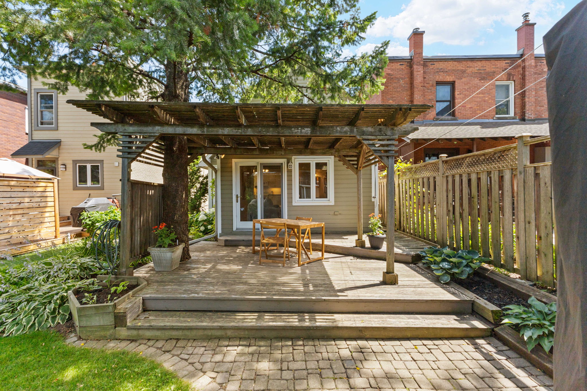 Back garden with a pergola and brick patio in Ottawa