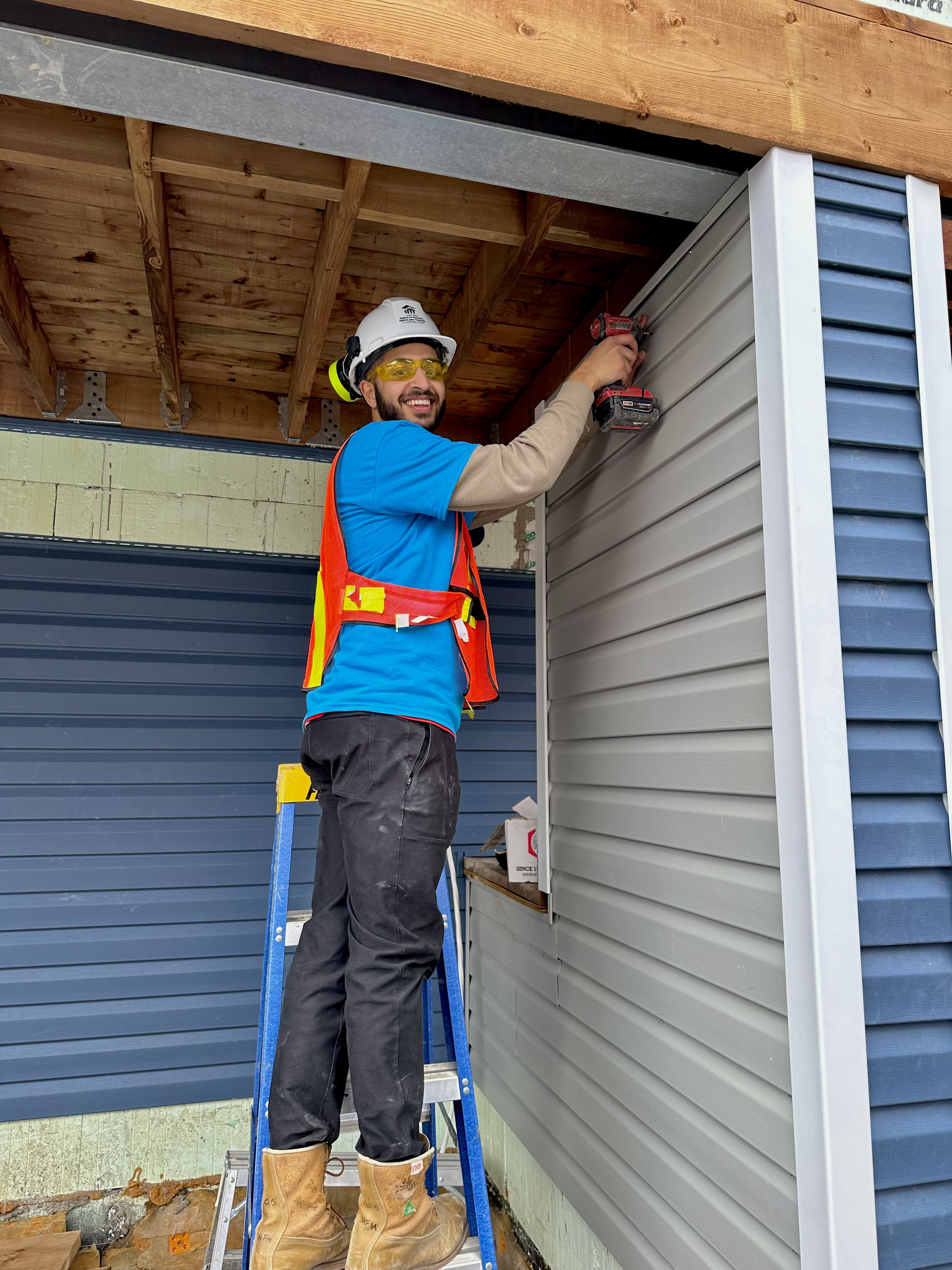 Jacob installing siding on a Habitat for Humanity build in Ottawa