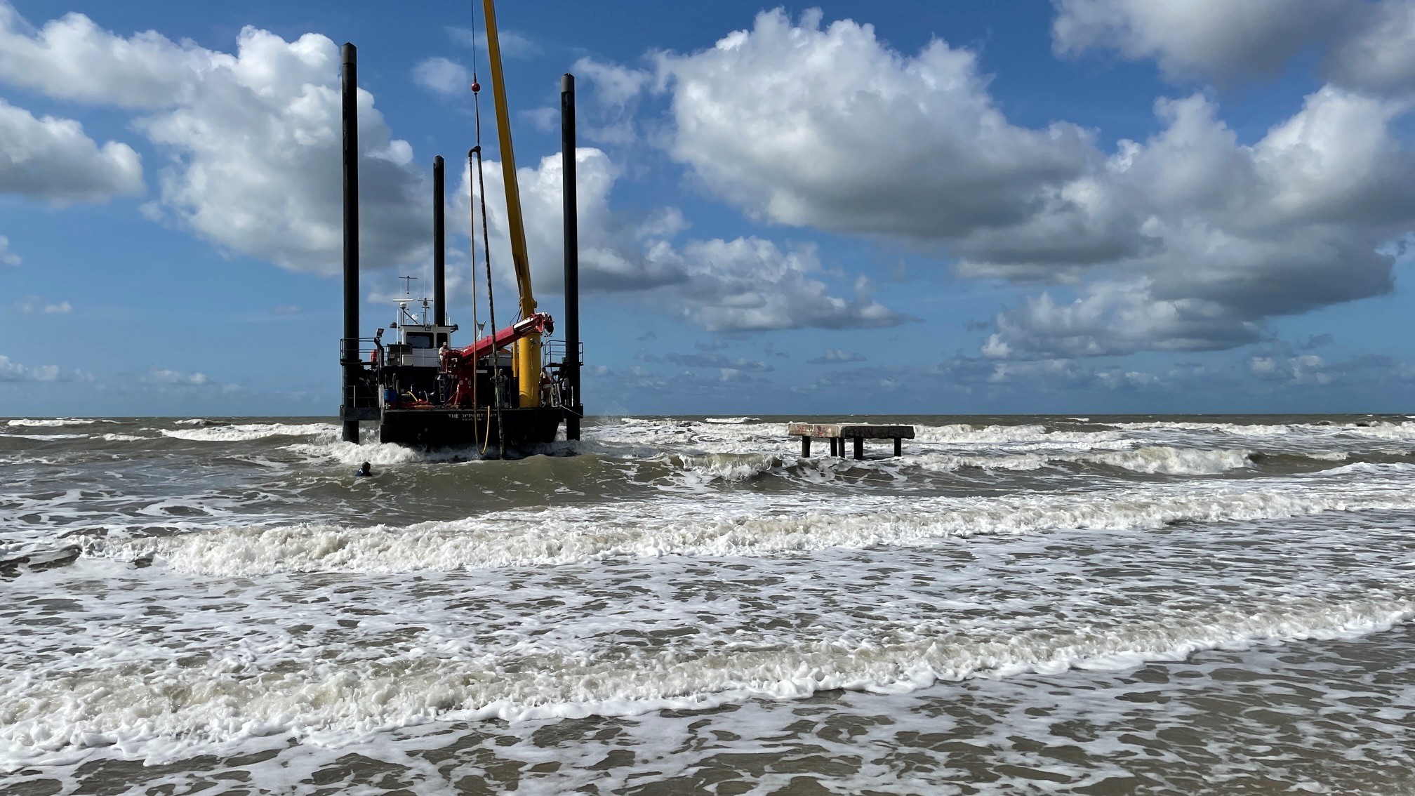 Salvage barge working in the surf off the Texas coast