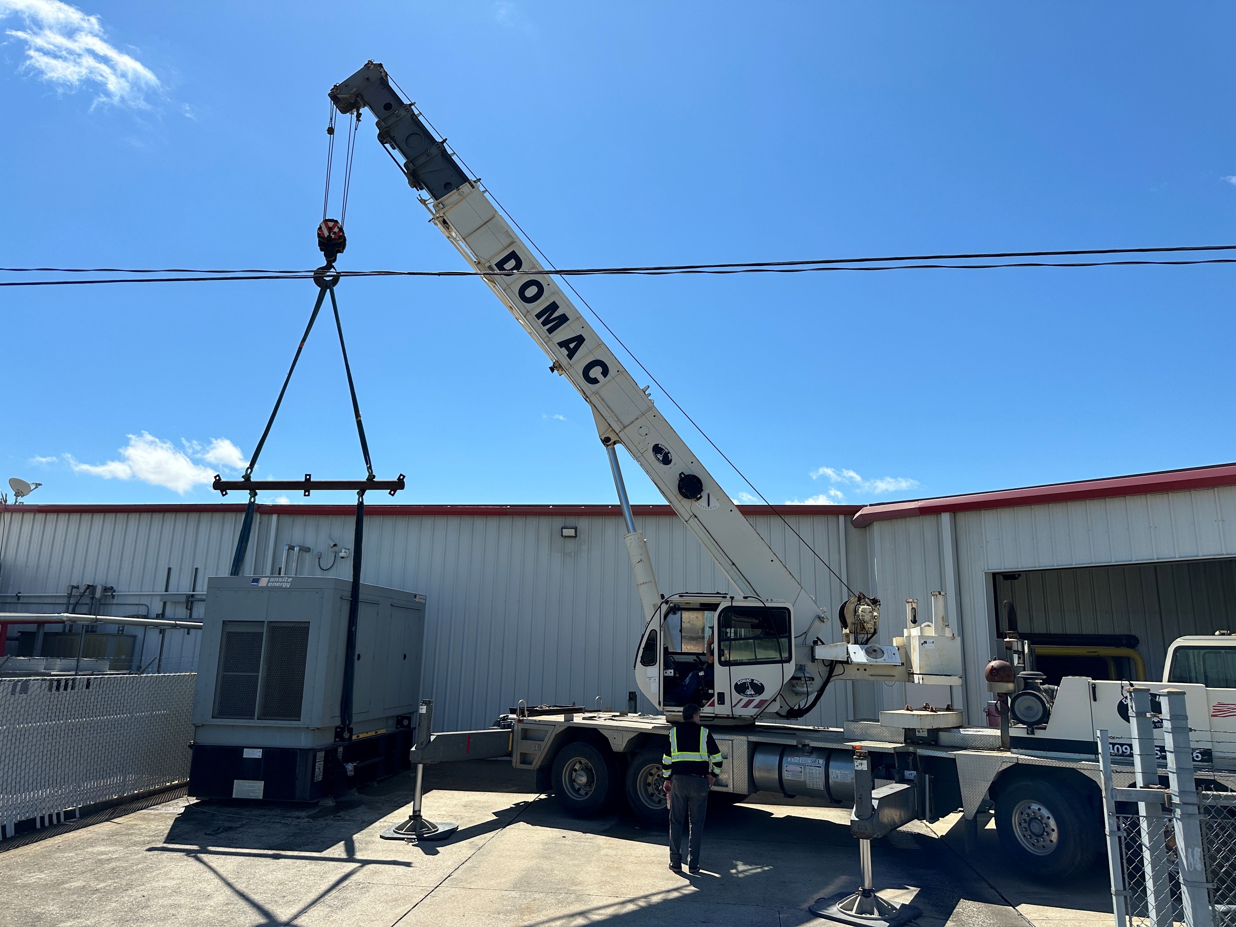 Crane setting a generator at a commercial building