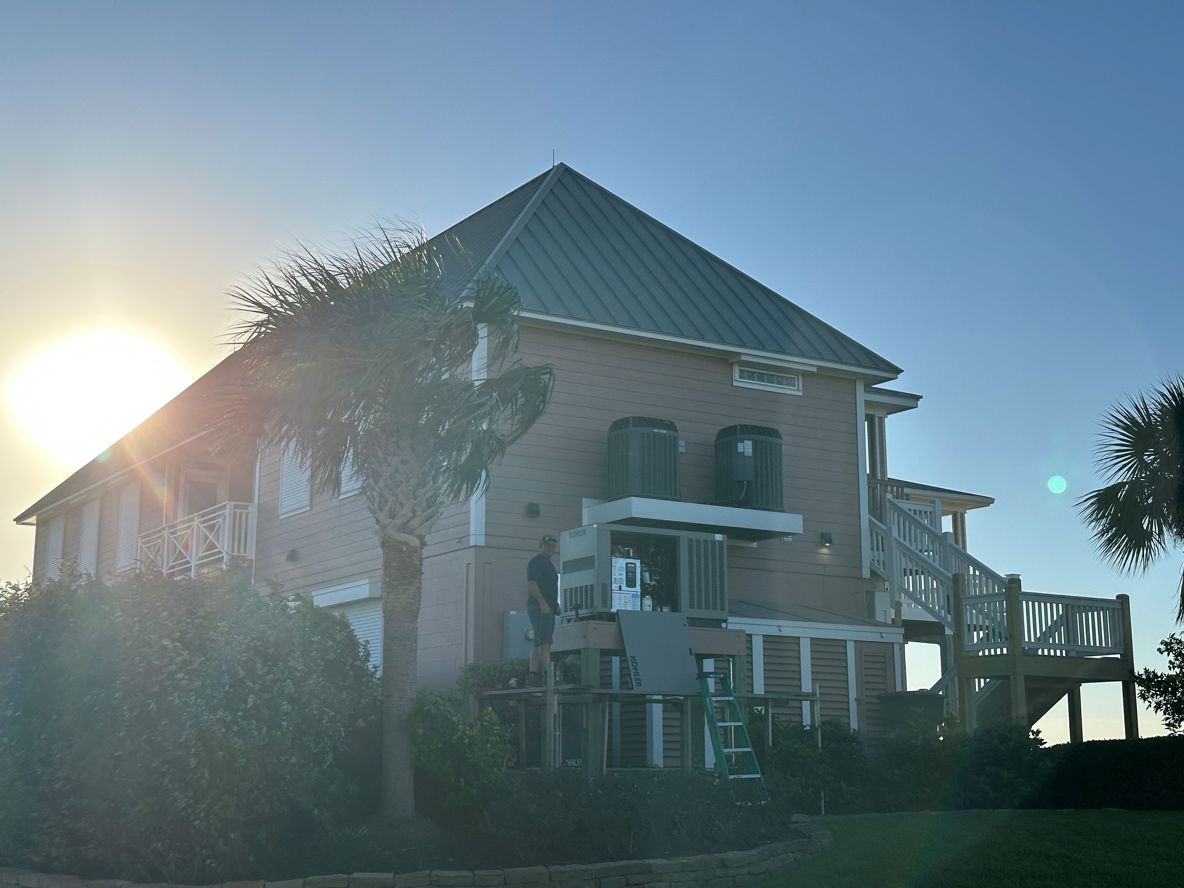 Raised coastal home at sunset after a generator install