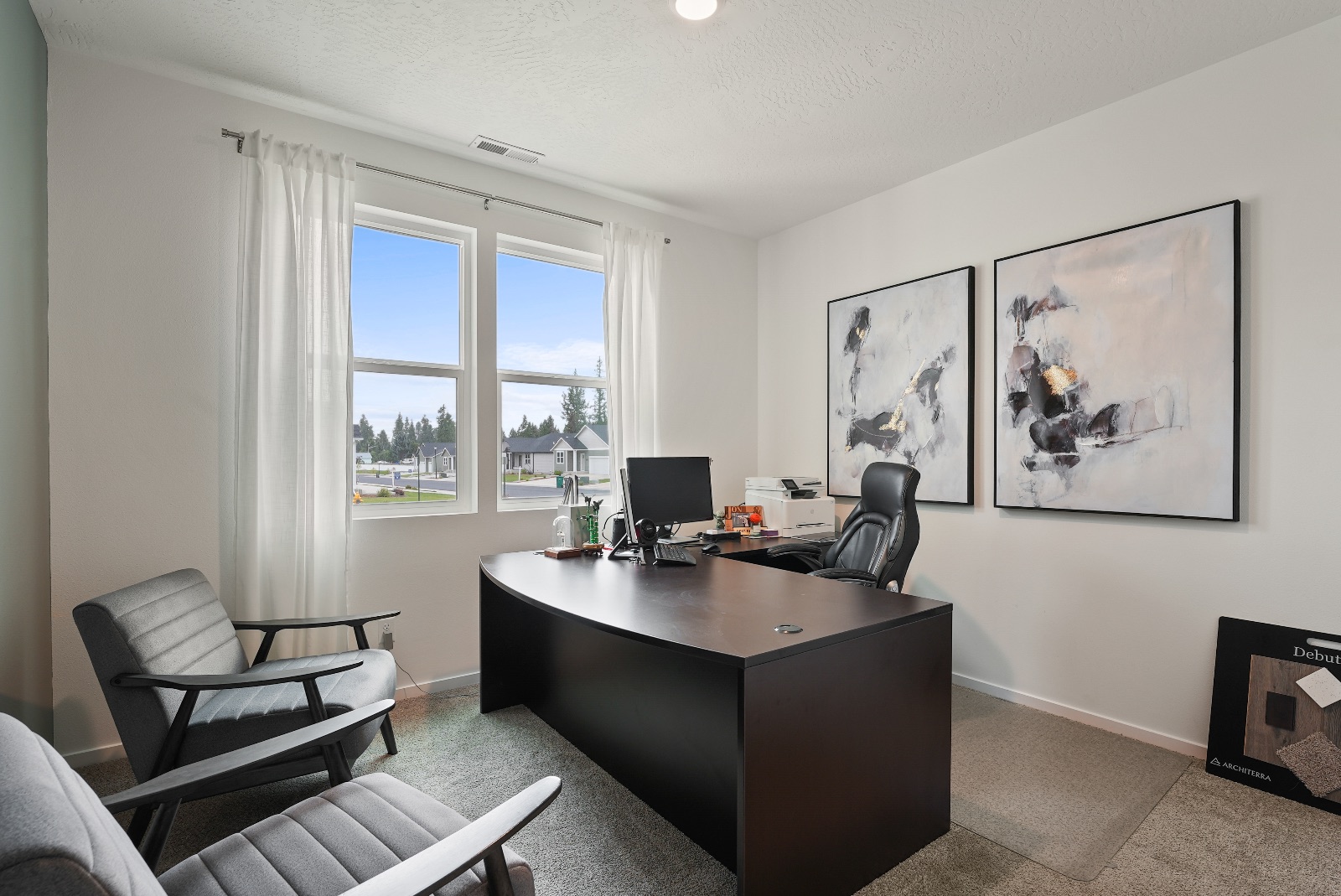 A front bedroom used as an office, with a corner window looking out over the street.