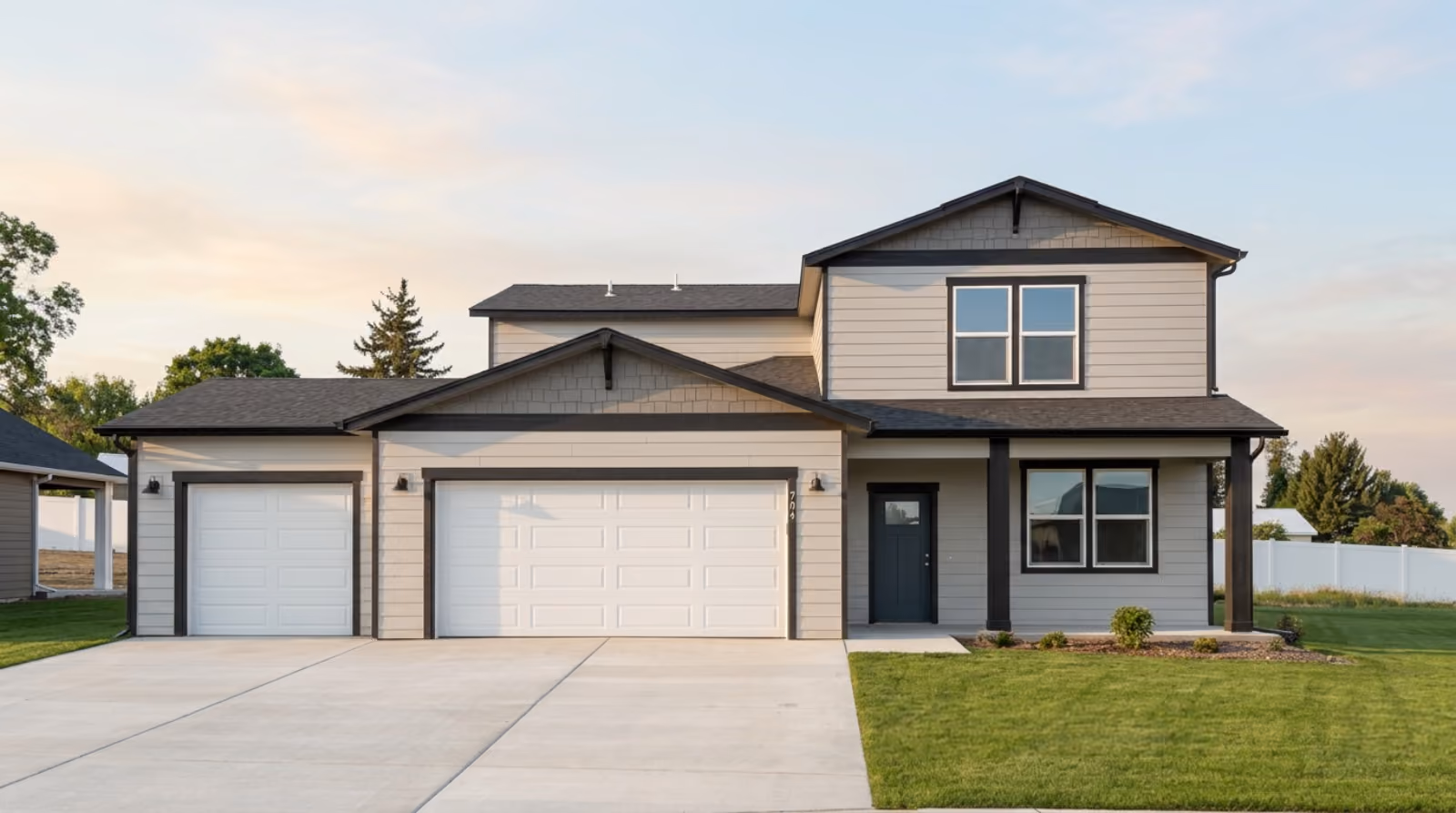 The front of 704 E 4th St: a two-storey Phoenix with a three-car garage.