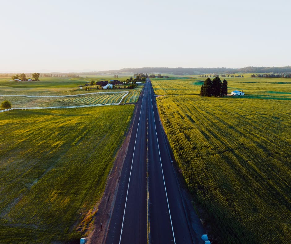 Two-lane highway running north through open farmland outside Deer Park, Washington.