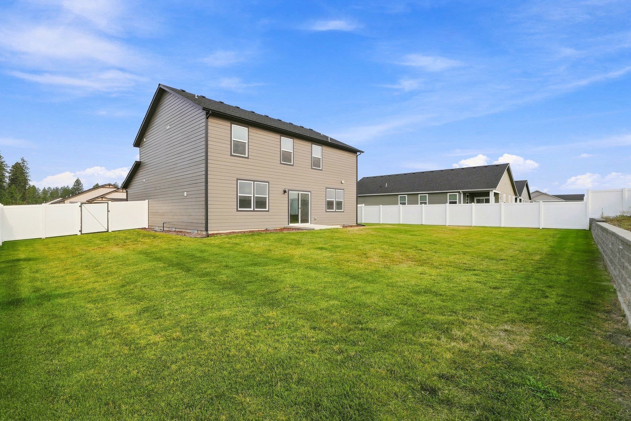 A Clearwater plan back yard: full lawn, vinyl privacy fencing, and a concrete patio at the slider.