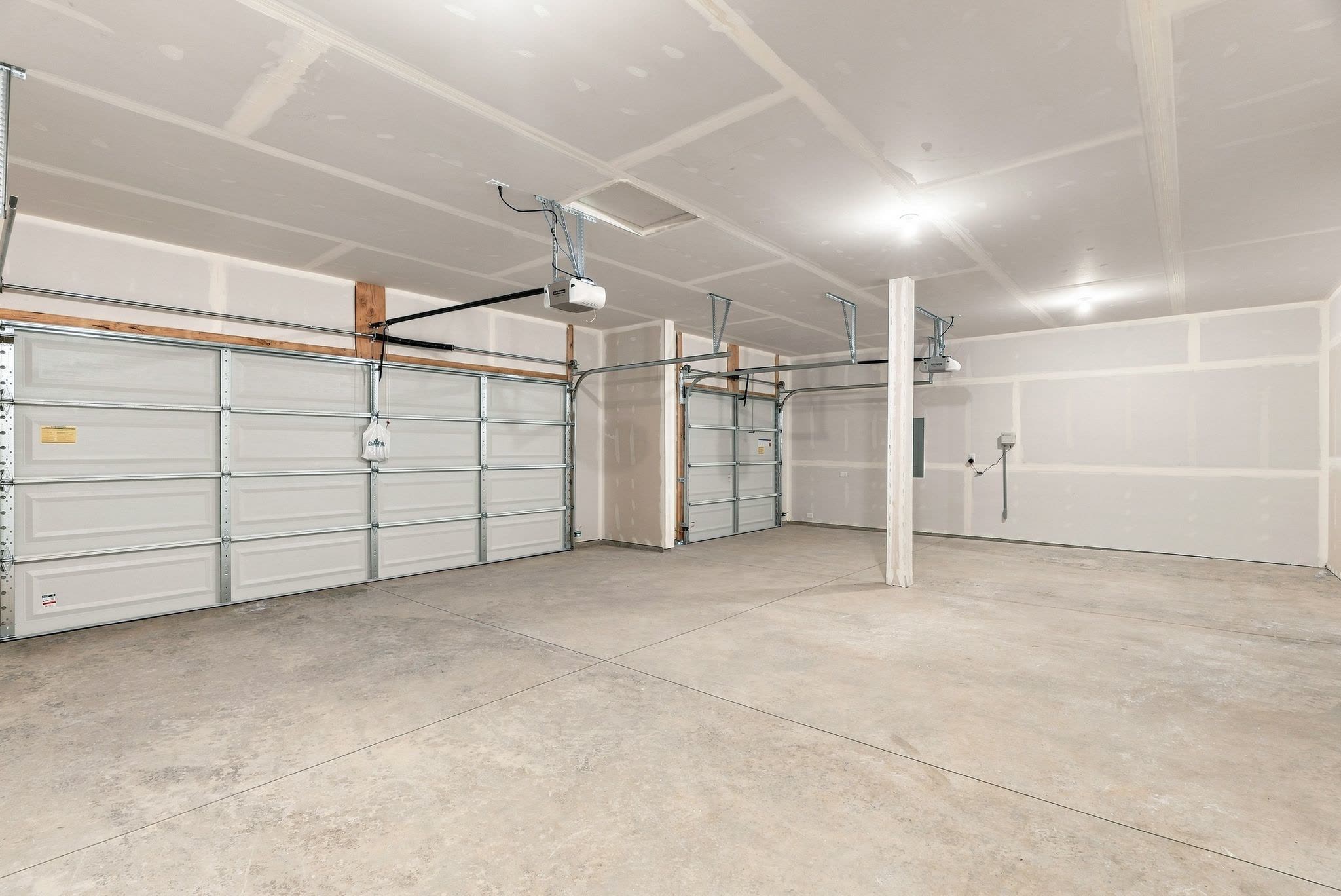 A Clearwater plan three-car garage, drywalled, with two openers fitted.