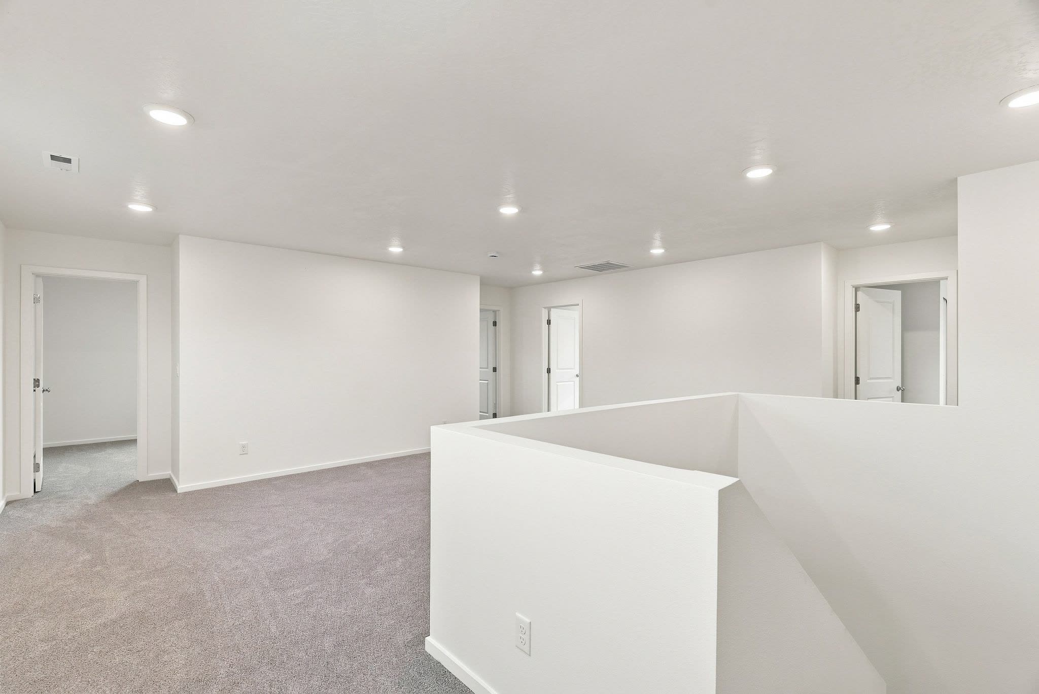 A Clearwater plan second-floor loft, carpeted, open over the stair with bedrooms off either side.