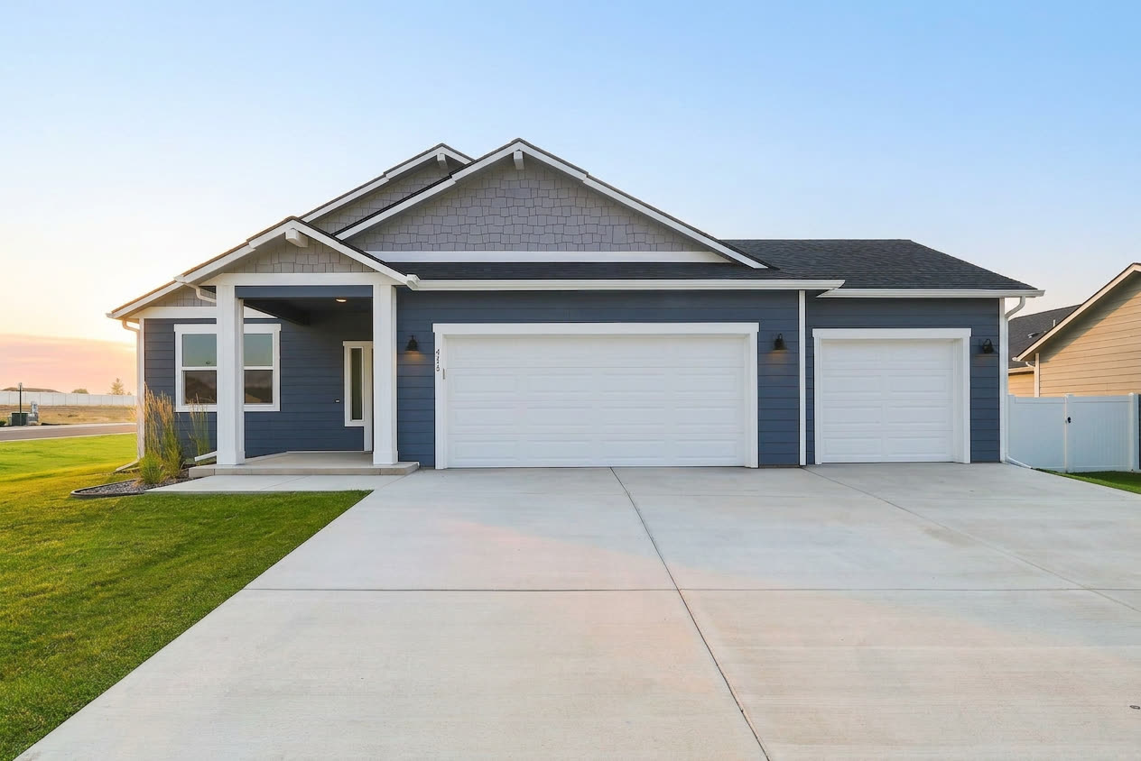 The front of 418 N Washington Ave at dusk: a single-story Eagle with a three-car garage.