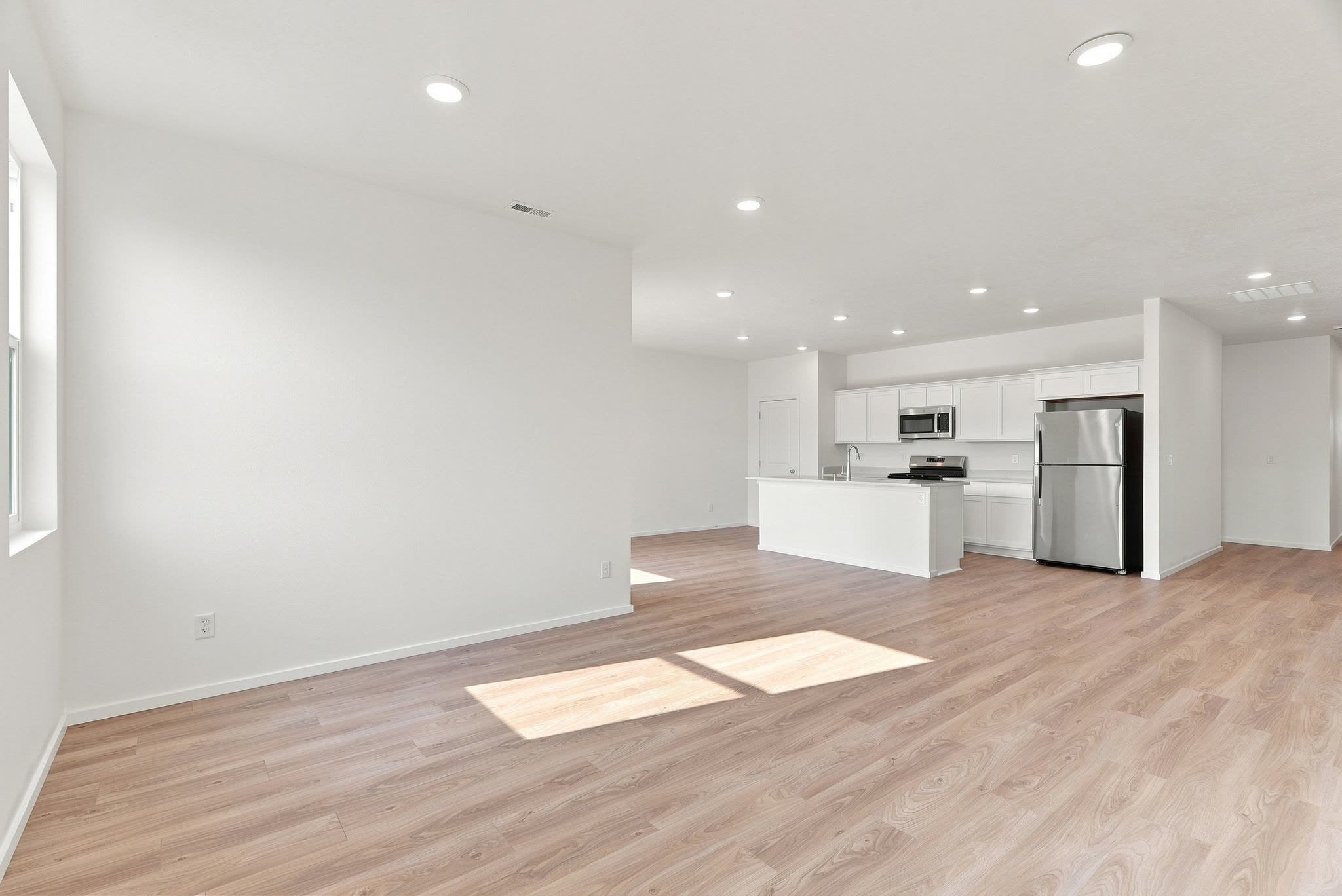 The great room at 418 N Washington, looking across luxury plank flooring to the kitchen beyond.
