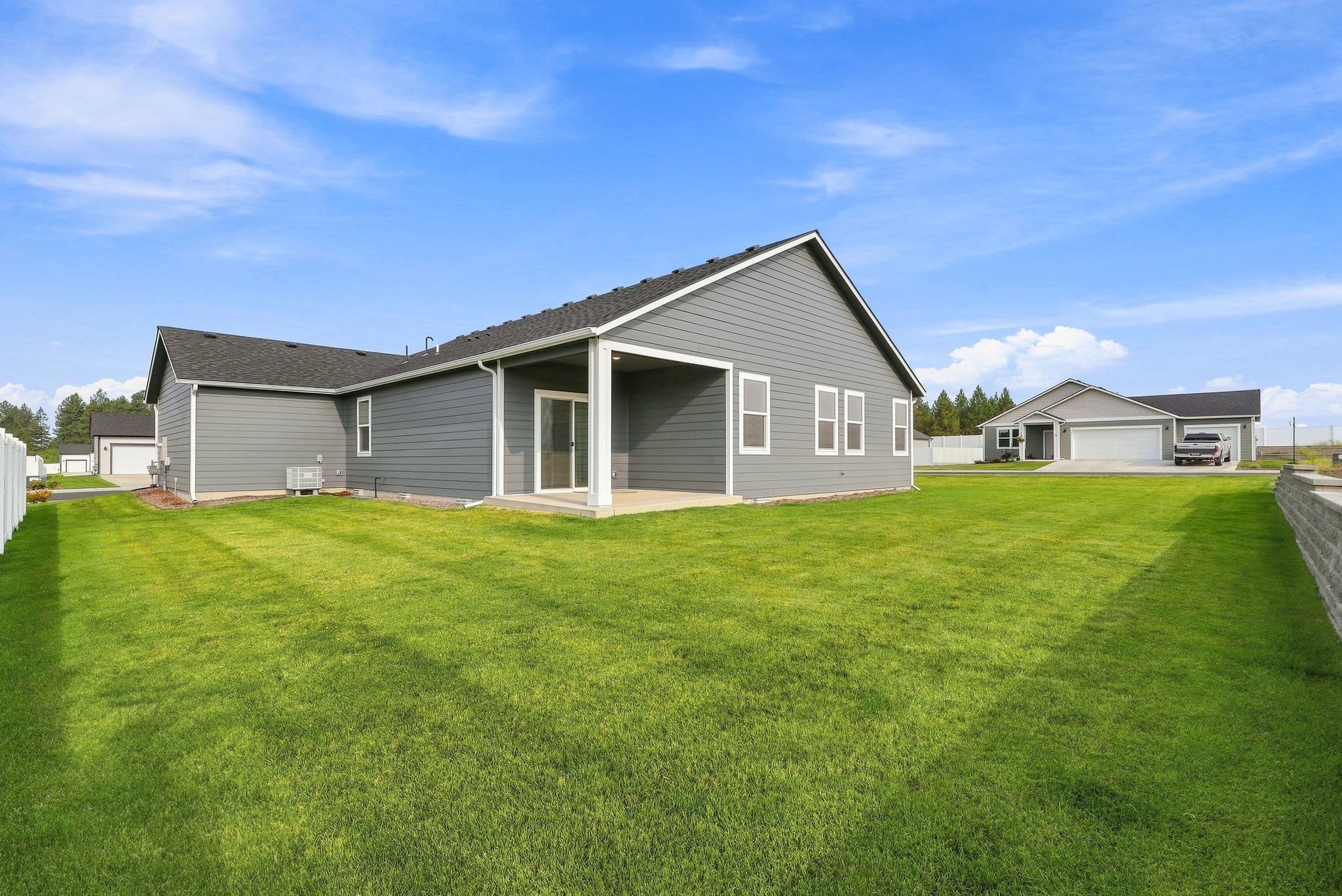 418 N Washington from the back yard: full lawn to the fence line, with the covered patio set into the rear elevation.