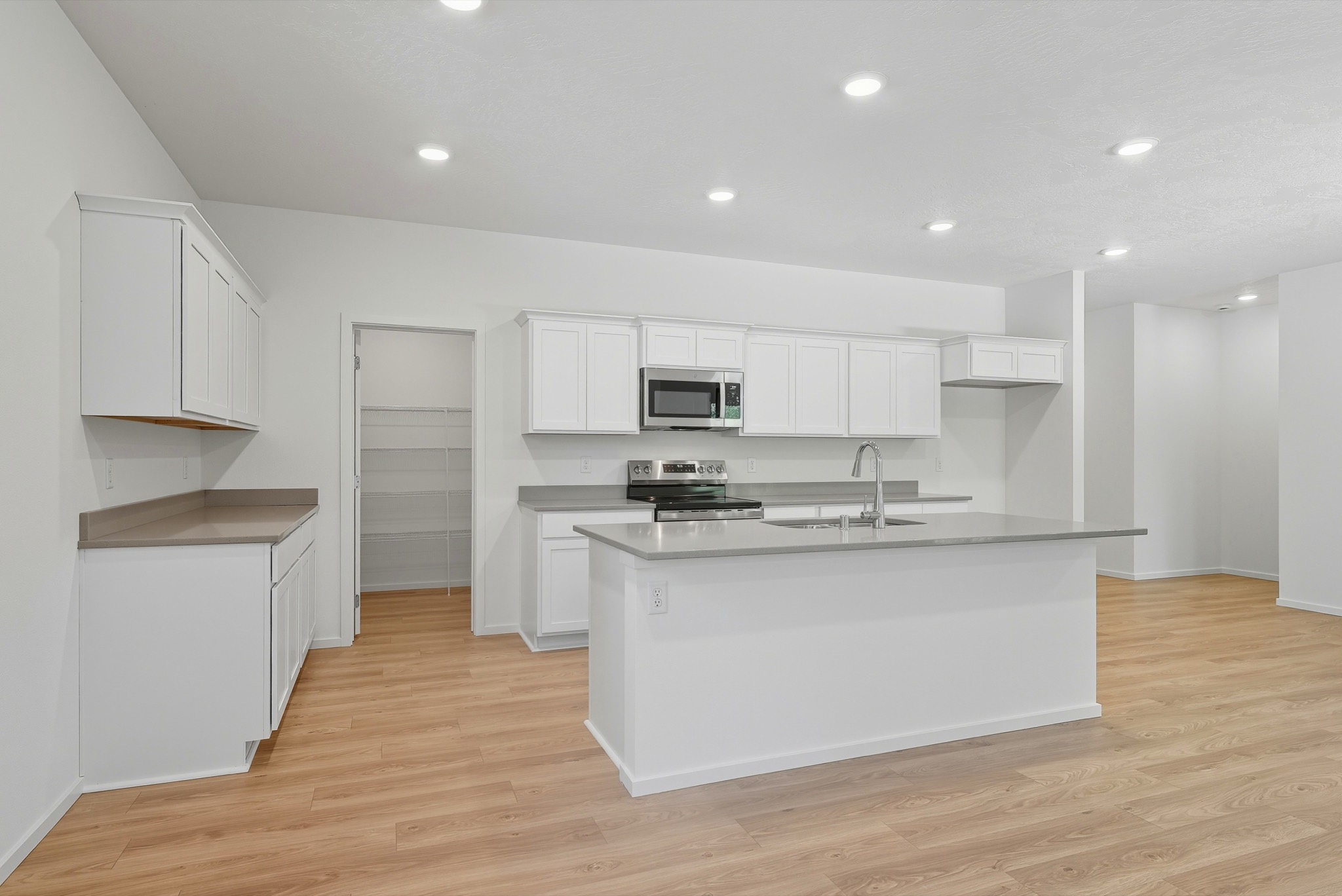The Clark Fork plan: the kitchen with a walk-in pantry, white shaker cabinetry and a vaulted ceiling.