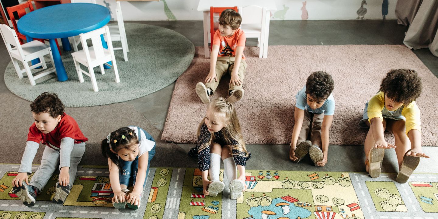 Children stretching on the floor at a daycare center
