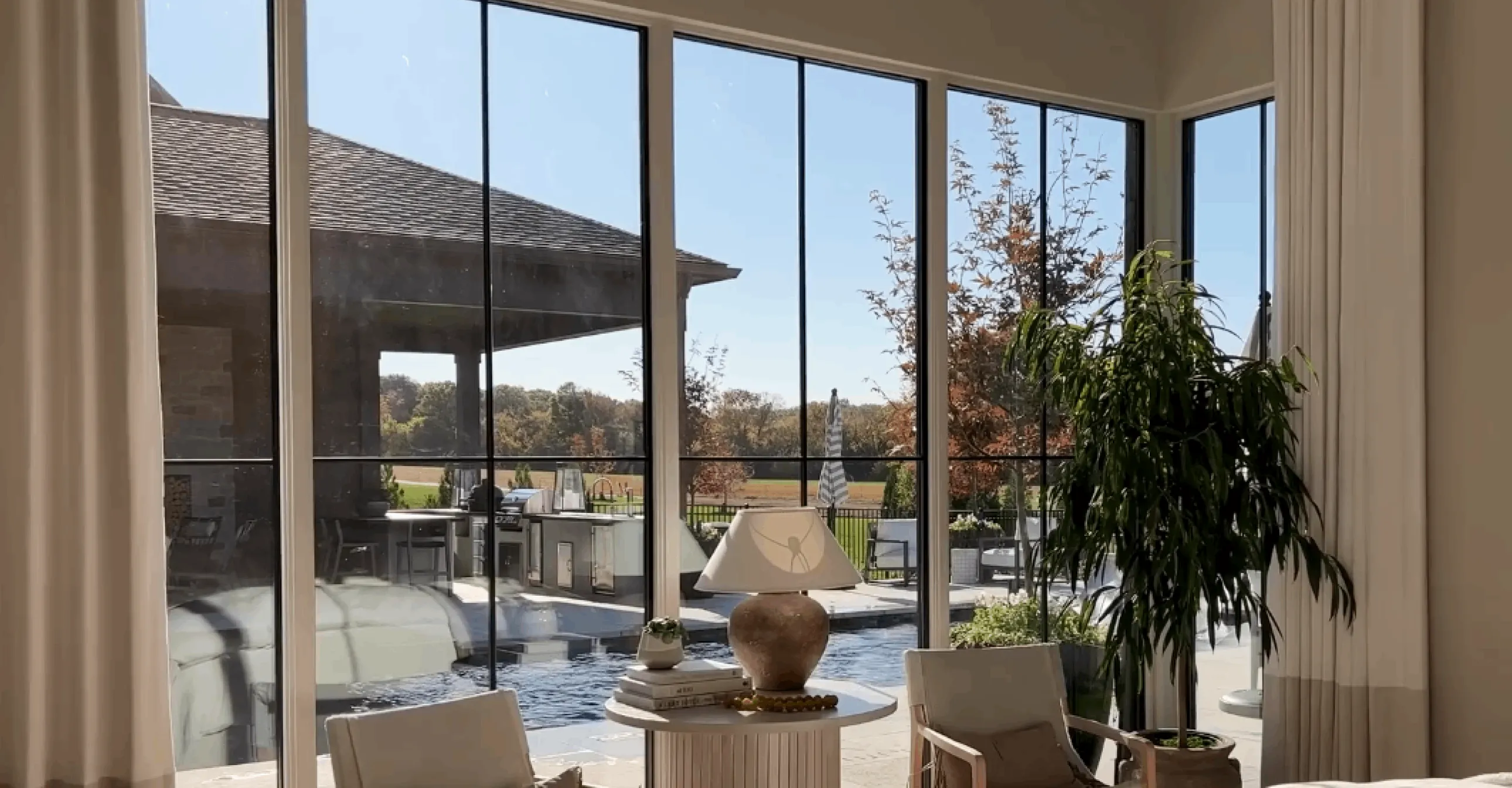 Sunlit sitting area overlooking a backyard pool