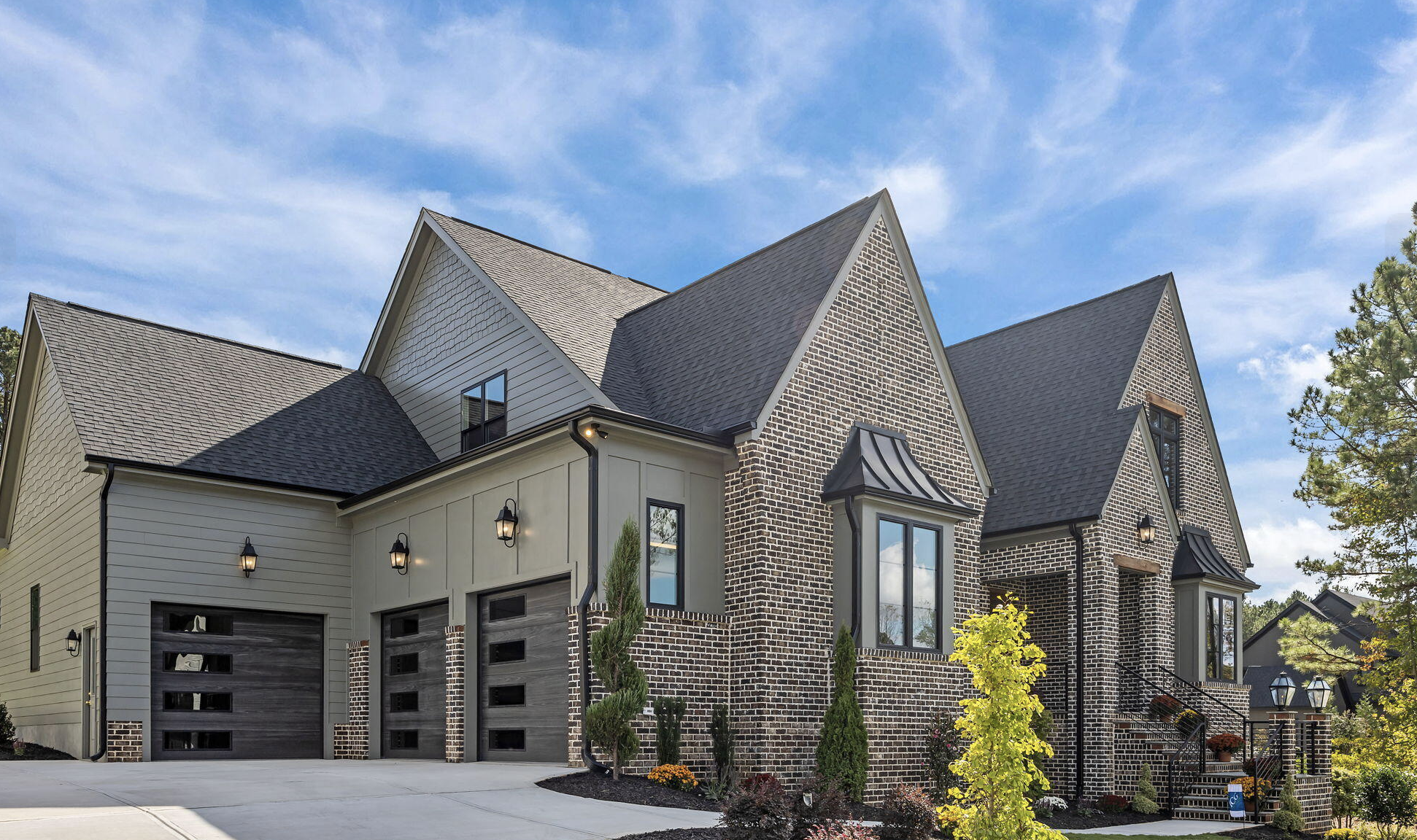 Brick and siding home with multiple garage doors
