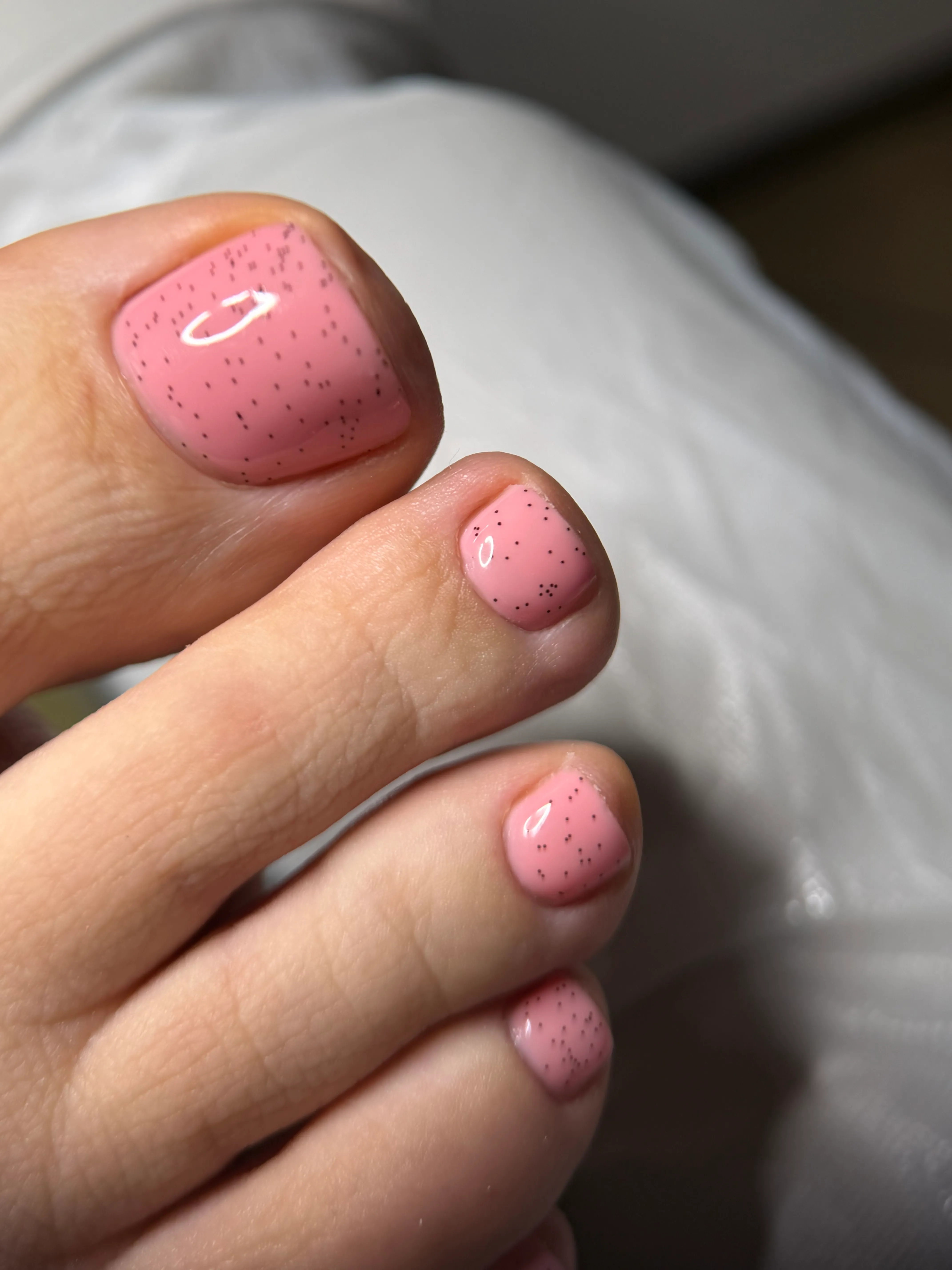 Rosa Zehennägel mit feinem Glitzer nach der Pediküre