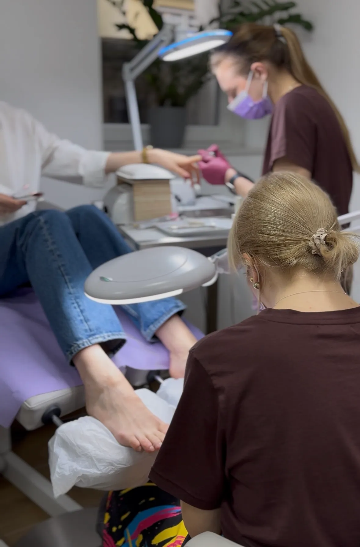 Zwei Nageldesignerinnen bei Maniküre und Pediküre an einer Kundin im Felena Studio