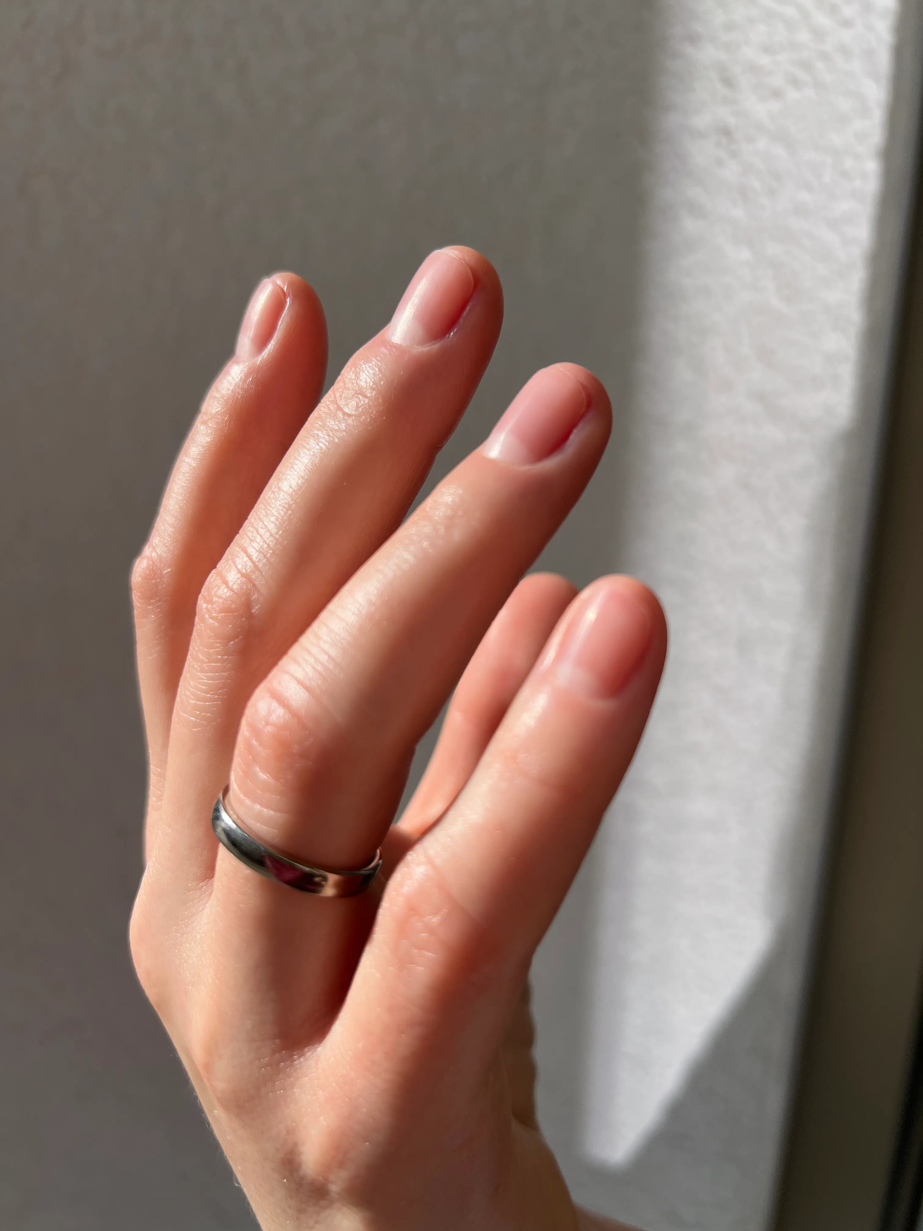 Kurze Naturnägel mit klarem Glanzfinish nach einer natürlichen Maniküre