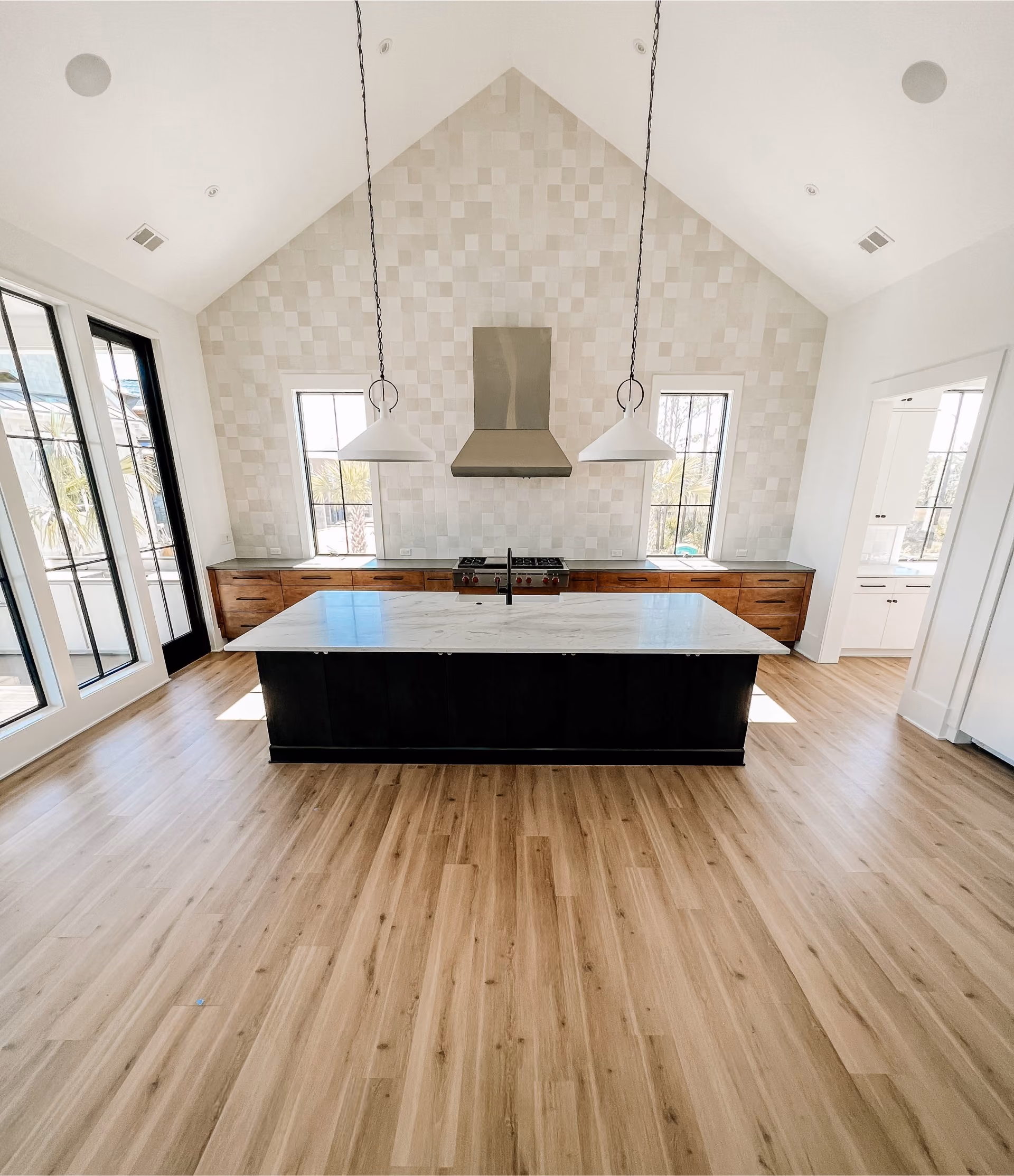 Kitchen with an island and vaulted ceiling on newly refinished light hardwood flooring