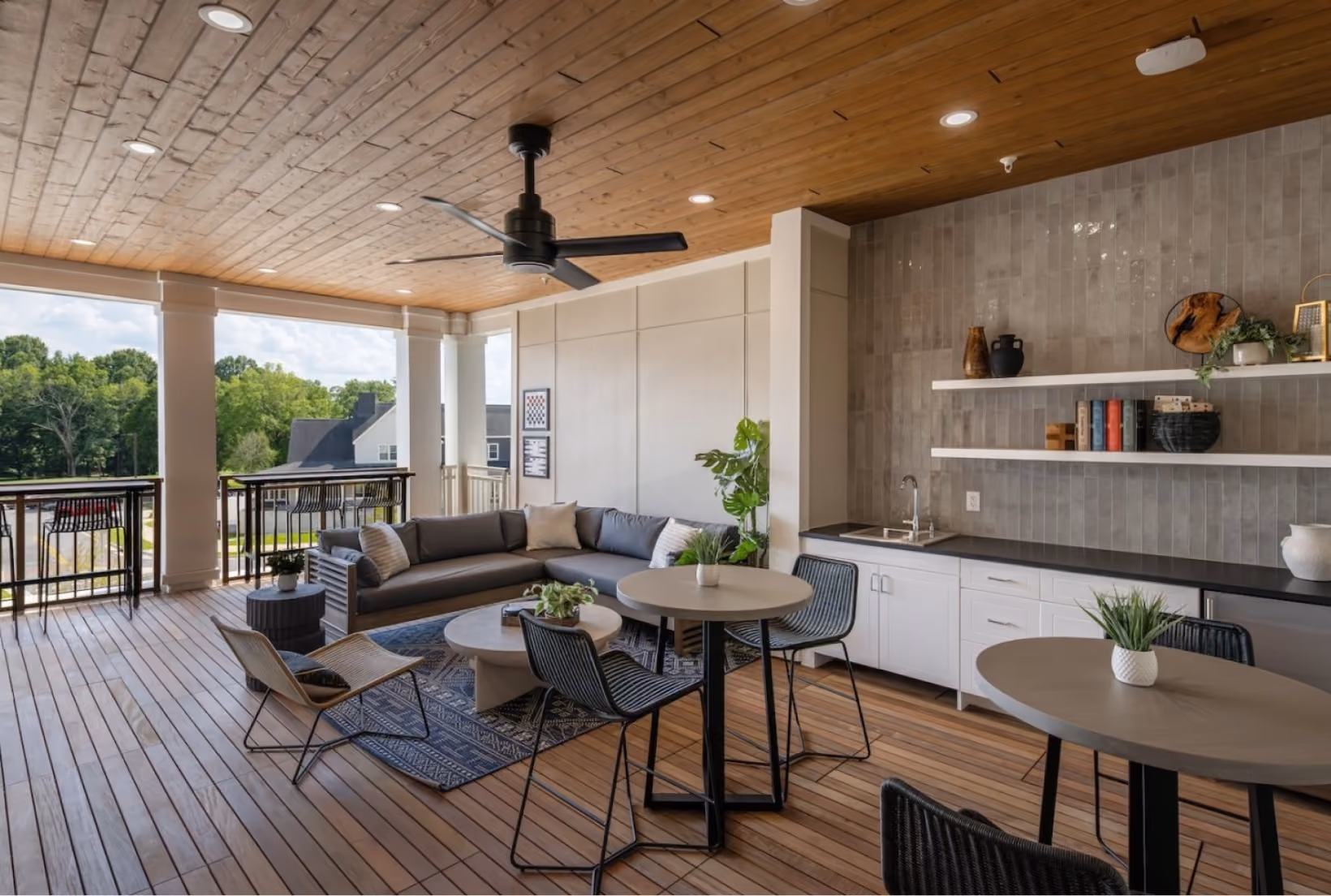 Covered outdoor porch with tile flooring, an outdoor kitchen, and lounge seating