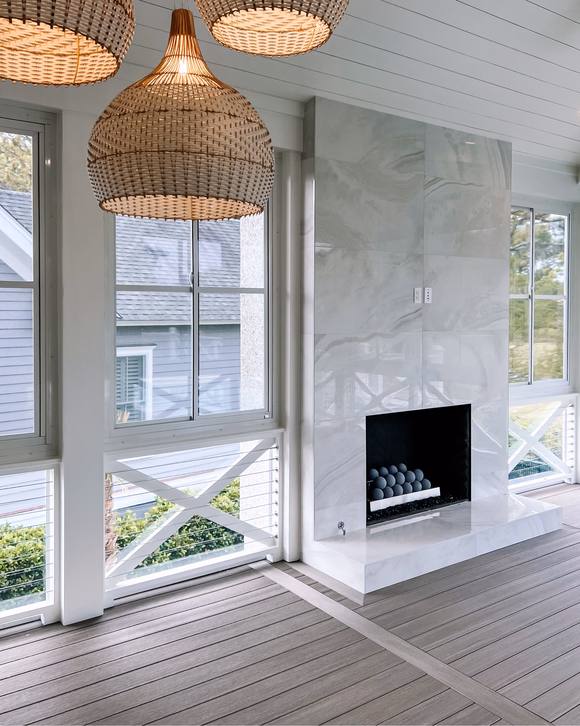 Sunroom with white marble-look tile flooring and a fireplace